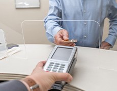 A man using his credit card to pay for dental care