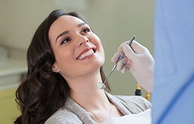 Smiling female patient in dentist’s chair