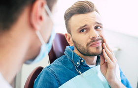 Patient with toothache looking at dentist