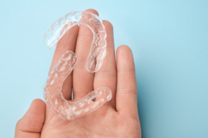 Close up of hand holding two clear aligner trays